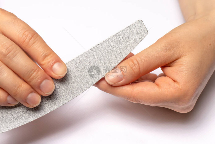 女指甲和指甲文件锯起钉子的边缘并划线在家里图片