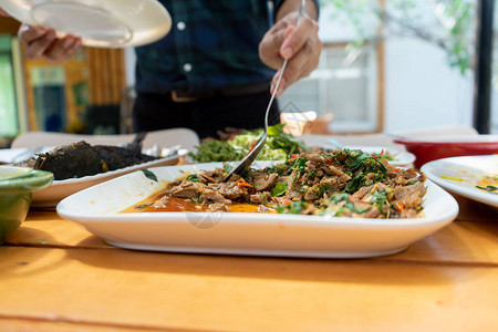 亚洲人用大勺子在午餐时捡到的烤鸭肉和烧烤鸡肉在木板图片