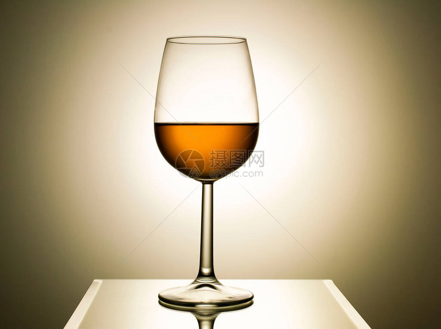透明玻璃与反光桌上的白葡萄酒在光的背景上葡萄酒商业摄影葡萄图片