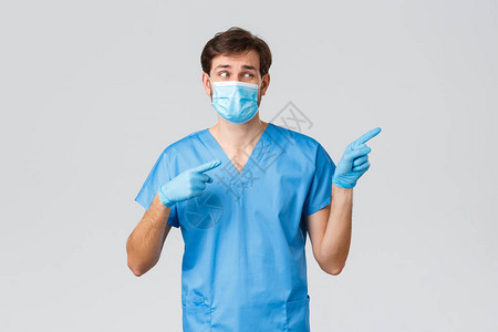 身穿蓝色磨砂橡胶手套和医用面具的医生指着手指图片