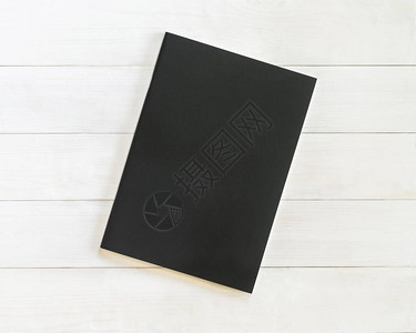 书籍模型空白黑色皮革A4尺寸封面模板平铺在白色木桌上图片