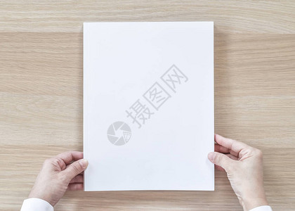 空白A4尺寸书籍封面样机模板顶视图在商人手中背景图片
