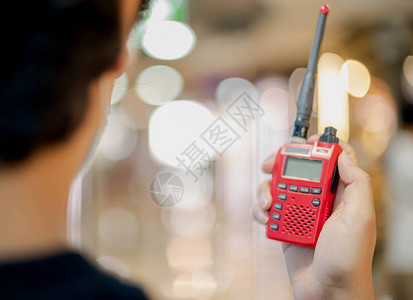 男手握着红色的对讲机或便携式无线电收发图片