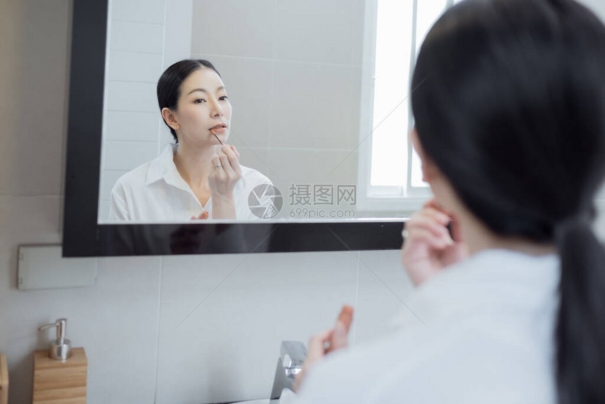 亚裔妇女穿着白衬衫在浴室的图片