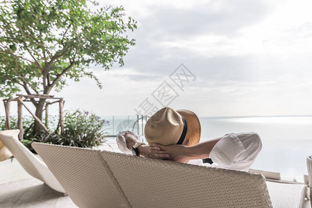 商人的放松假期轻松愉快地在游泳池畔海滨度假酒店的沙滩椅上休息图片