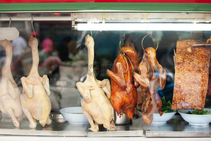鸭煮鸡肉和烤猪肉挂在唐人街一家当地图片