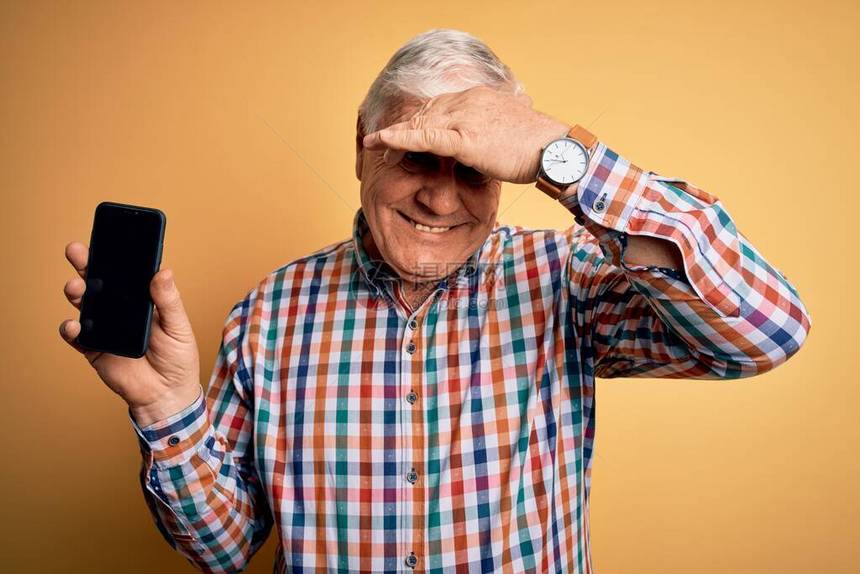 年长英俊的白发老人手持智能手机图片