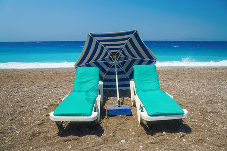 沙滩对海面的沙滩上有两个防晒床图片