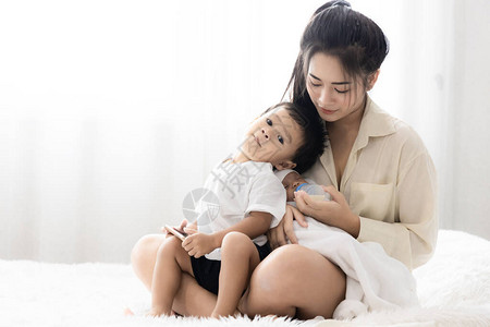 年轻的亚洲母亲抱着一个可爱的新生婴儿图片