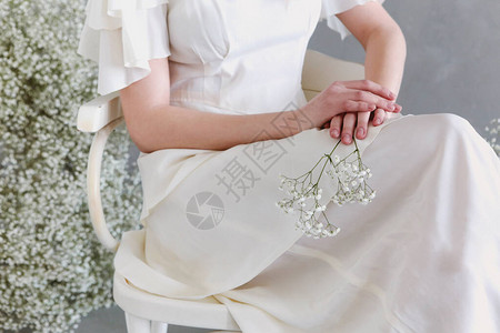 穿着老式白色连衣裙的不露面优雅女人坐在椅子上图片