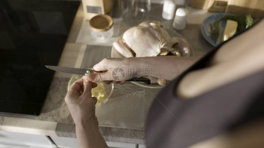 感的女人腌制准备用大蒜烤鸡的敷料女人在厨房用刀切大蒜的特图片