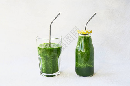 用小瓶装菠菜和用金属吸管装着饮料杯的绿色冰淇淋图片