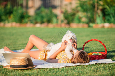 快乐的小女孩和一条狗去野餐玩乐女孩正在户外图片