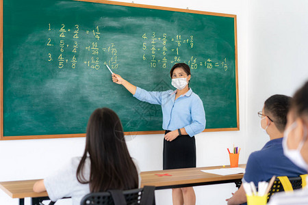 一群亚洲小学生和老师戴着卫生口罩图片
