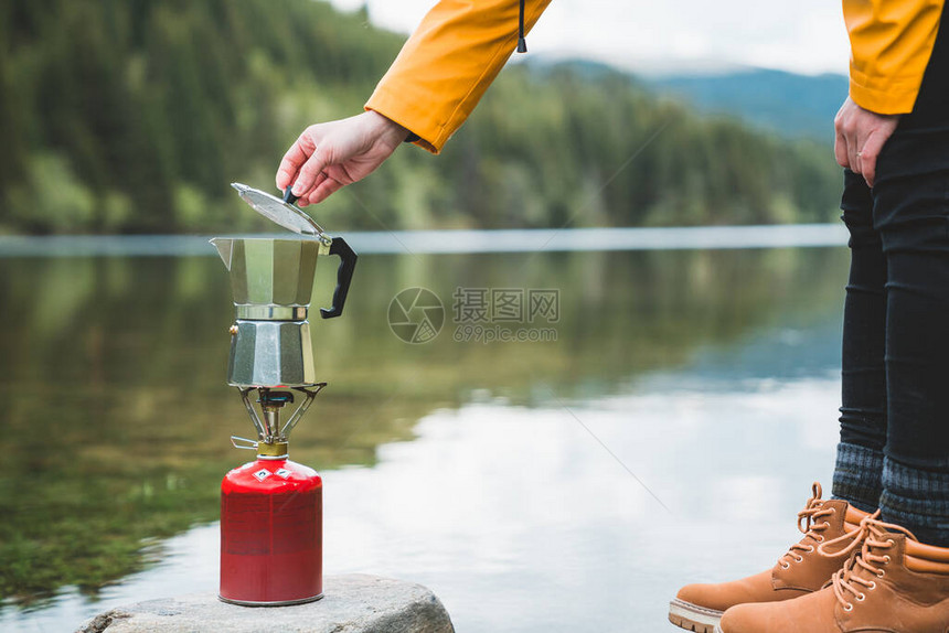 用意大利咖啡机摩卡在野营燃气灶或炊具上准备茶或咖啡的女手在大自然户外野营烹饪户外旅游休闲和图片