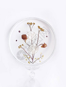 网眼织物网格薄纱背景圆环上的干花和枯草的手工刺绣图片