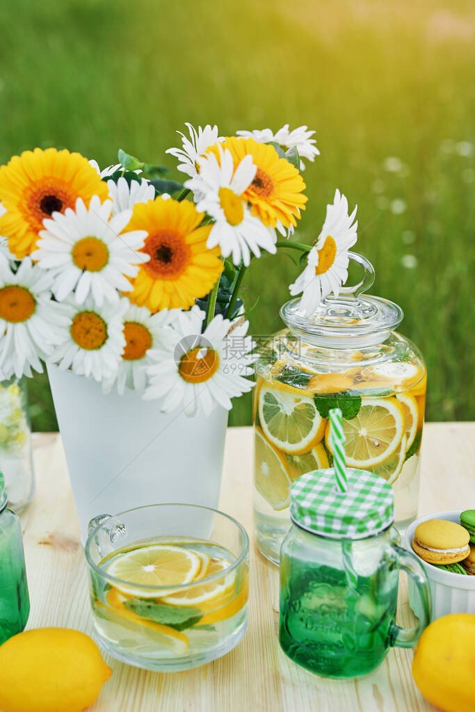 柠檬水和雏菊花在桌子上梅森罐玻璃柠檬水舒适的早晨春季和夏季节卡健康食品和饮料暑假户外野餐图片