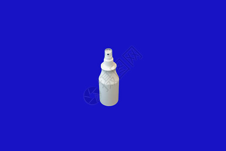 蓝色对比色背景上的小白色喷雾瓶图片