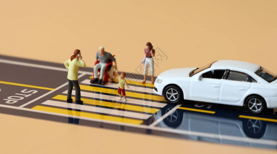 越过截断线的微型汽车和穿越交叉路口的小型人图片