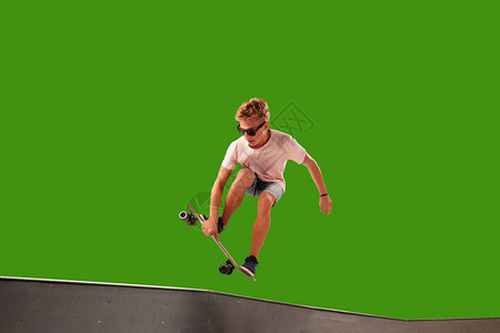 在绿屏上孤立的滑板手图片