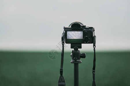 三脚架上的相机站在田野里自然景观的静态摄影现代图片