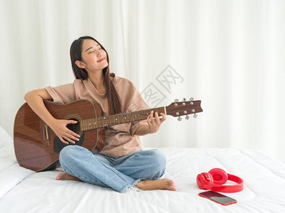 青少年在卧室里弹吉他图片