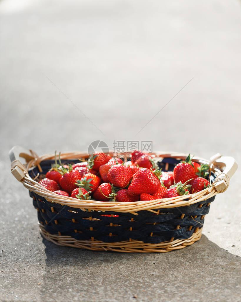 在混凝土背景的草莓篮图片