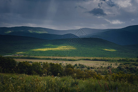 雷雨前山间风景如画的绿色山谷图片