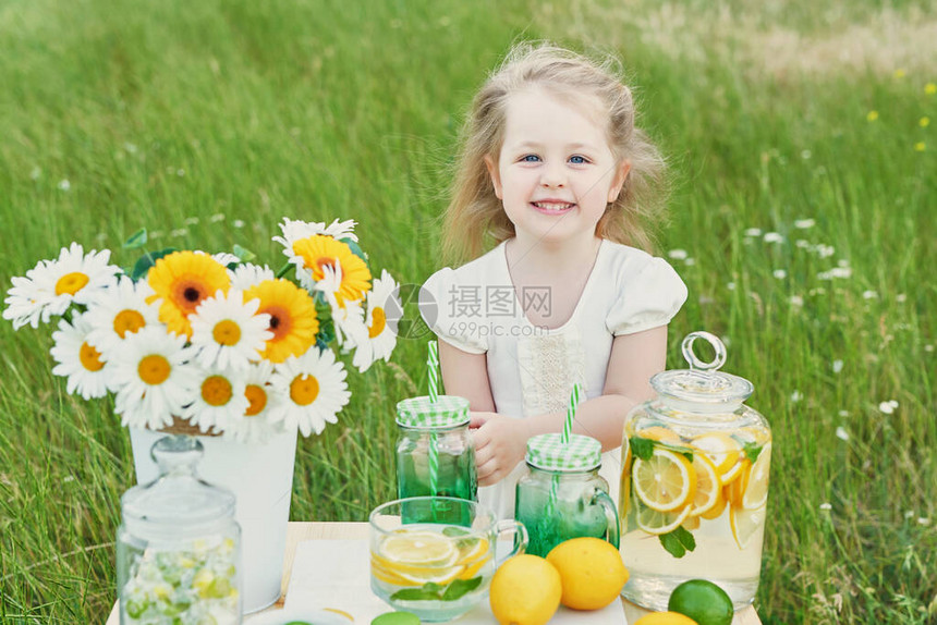 儿童女孩用柠檬水柠檬水和雏菊花在桌子上舒适的早晨春季和夏季节卡健康食品和饮料暑假户外野餐图片