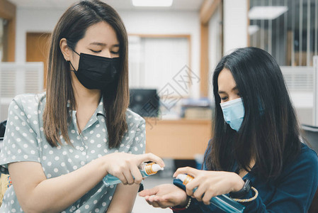亚洲女戴口罩和酒精抗菌手凝胶呼吸防护面罩图片