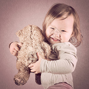 可爱的亚裔女婴她手里拿着泰迪熊棕色图片
