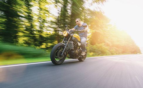 现代扰频器摩托车在日落时骑摩托车的道路上个人文图片