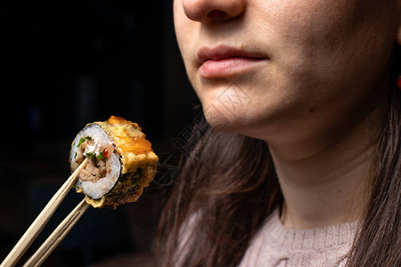 女人拿着一卷木棍做寿司海食生鱼图片