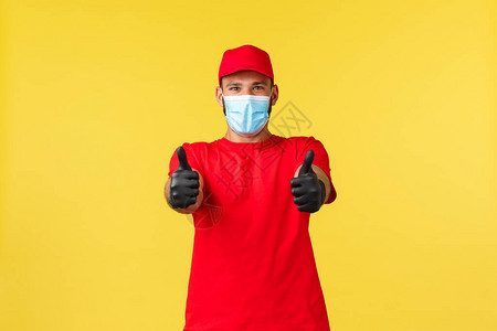 穿着红色制服医用口罩和手套的乐观快递员图片