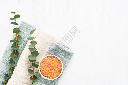 卷毛巾橙色浴盐和白色背景上的叶片纹卫生健康身体护理概念文本复制空图片