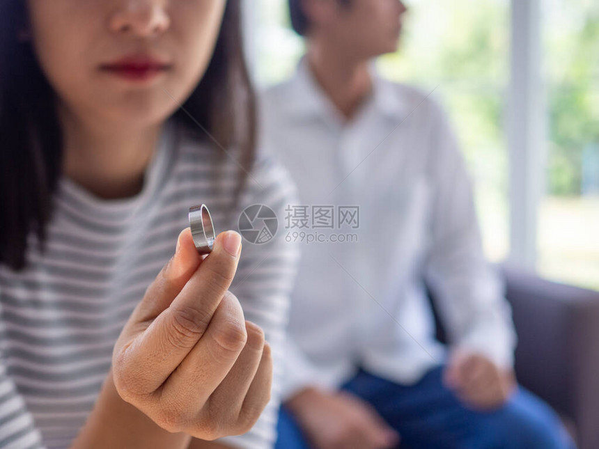 一位亚洲女正在脱下婚戒图片