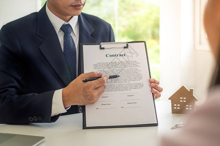 房屋销售代表正在向客户或新房东签署合同或购房文件的详细信息签图片