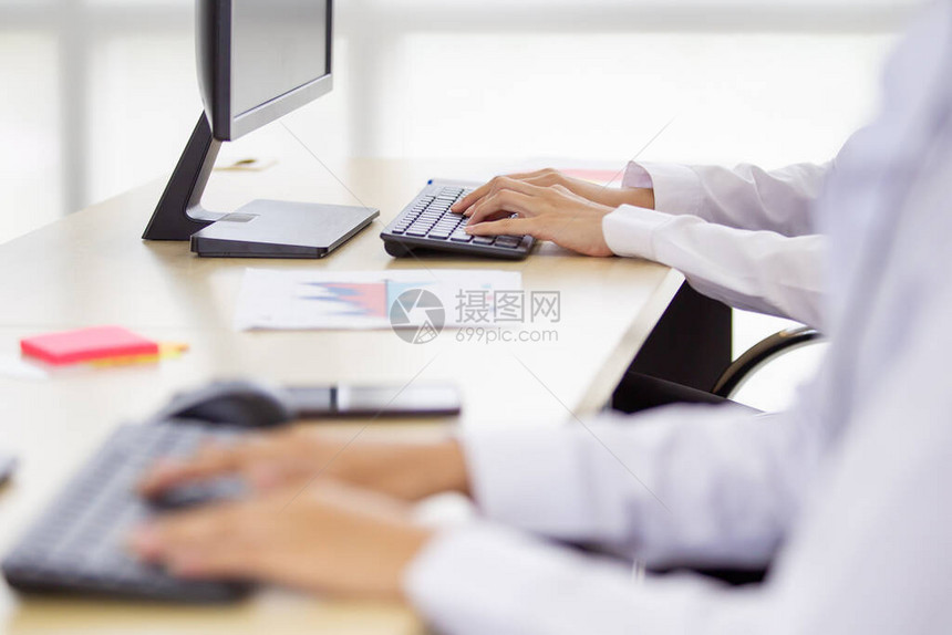雇员用台式计算机在键盘和键盘上写电子邮件图片