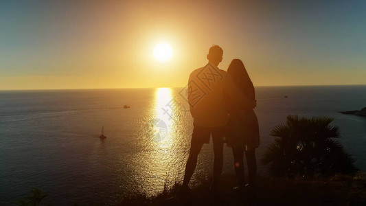 浪漫的情侣拥抱站在海滩边缘图片