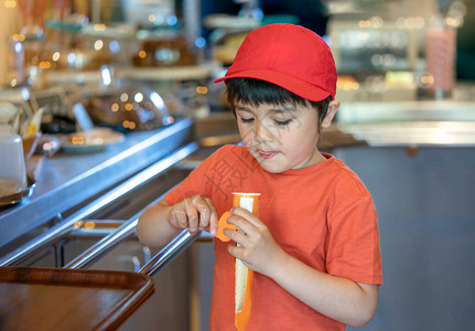 快乐的孩子站在蛋糕店前吃冰淇淋棒糖图片