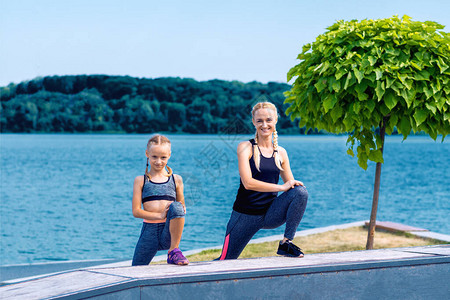 湖岸上穿着运动风格服装的母亲和孩子的图片
