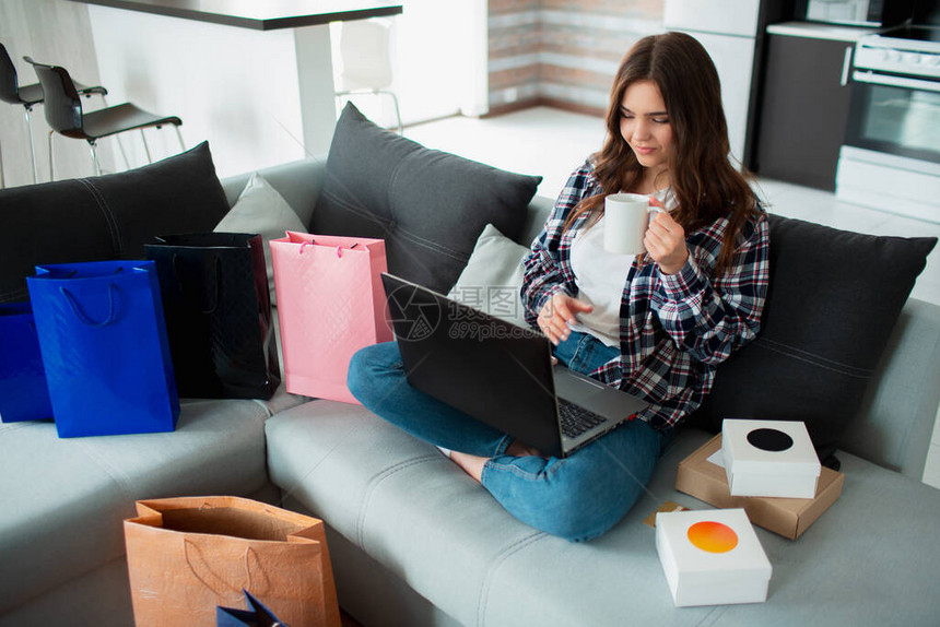 隔离期间在家购物狂一位年轻女子使用笔记本电脑并在网上购买大量商品她正在订购各种东图片
