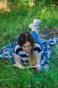 美丽的年轻女子在公园里读书图片