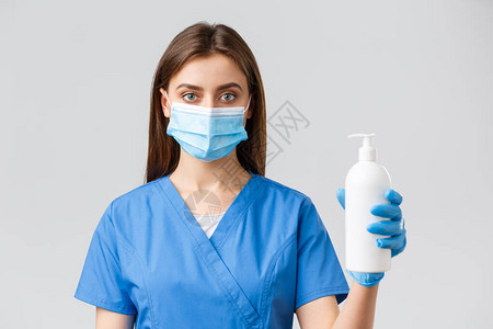 穿着蓝色磨砂和医用面具的严肃医务工作者护士或医生图片