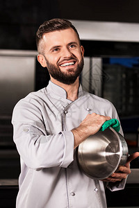 男厨师用抹布擦碗与绿色除尘器合影的厨师人笑脸厨师在专业厨房用绿图片