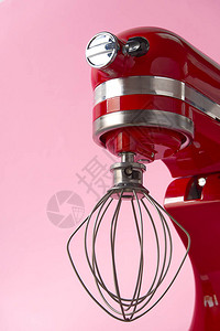 粉色背景上孤立的红厨房混音器与金属威斯克的专业钢电动搅音器图片