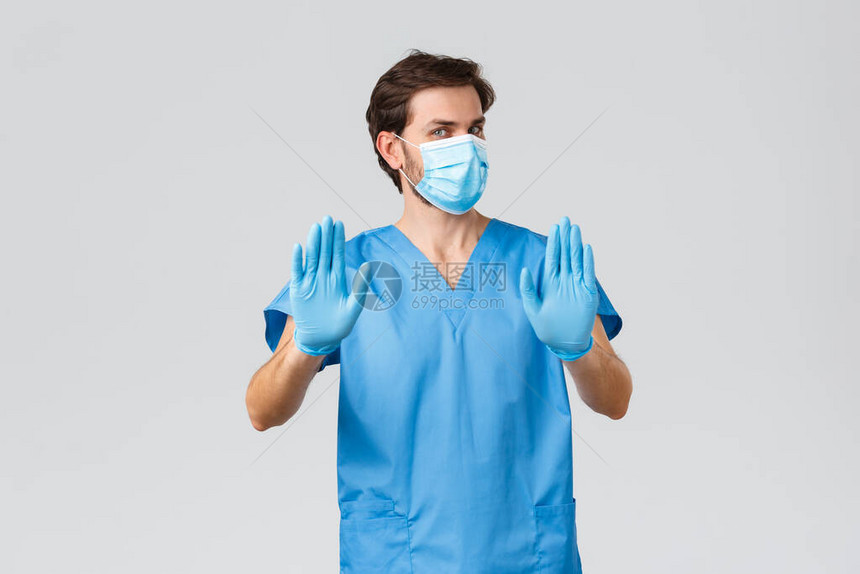戴着医用口罩手套和磨砂膏的不情愿和不高兴的医生图片