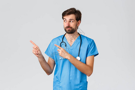 不确定和优柔寡断的大胡子医生医生或护士在磨砂膏听诊器假笑图片