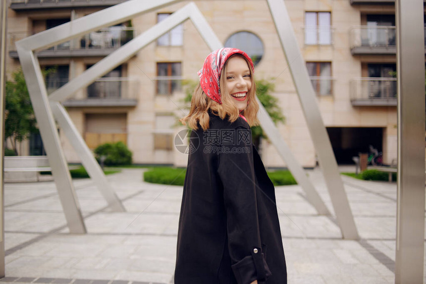 一个身穿西装头戴红围巾以建筑物为背景的女孩图片