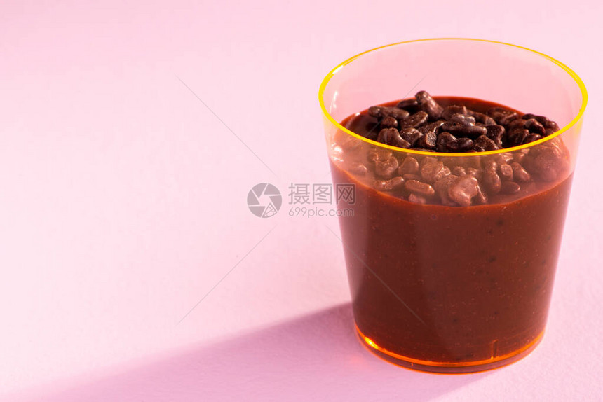 丁香背景上洒有brigadeiro和巧克力的丙烯酸杯图片